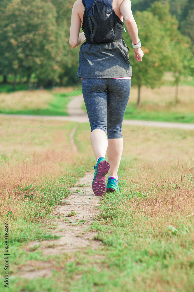 Active beautiful woman running in the city park outdoor. Healthy lifestyle. Back view Active beautiful woman running in the city park outdoor. Healthy lifestyle. Back view