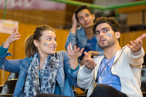 Obraz na plátne animated sport supporters wearing facepaint making hand gestures