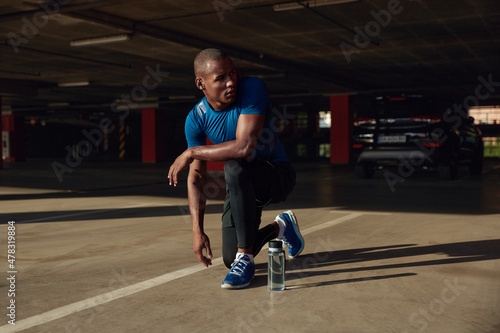 Black sportsman with water on parking lot