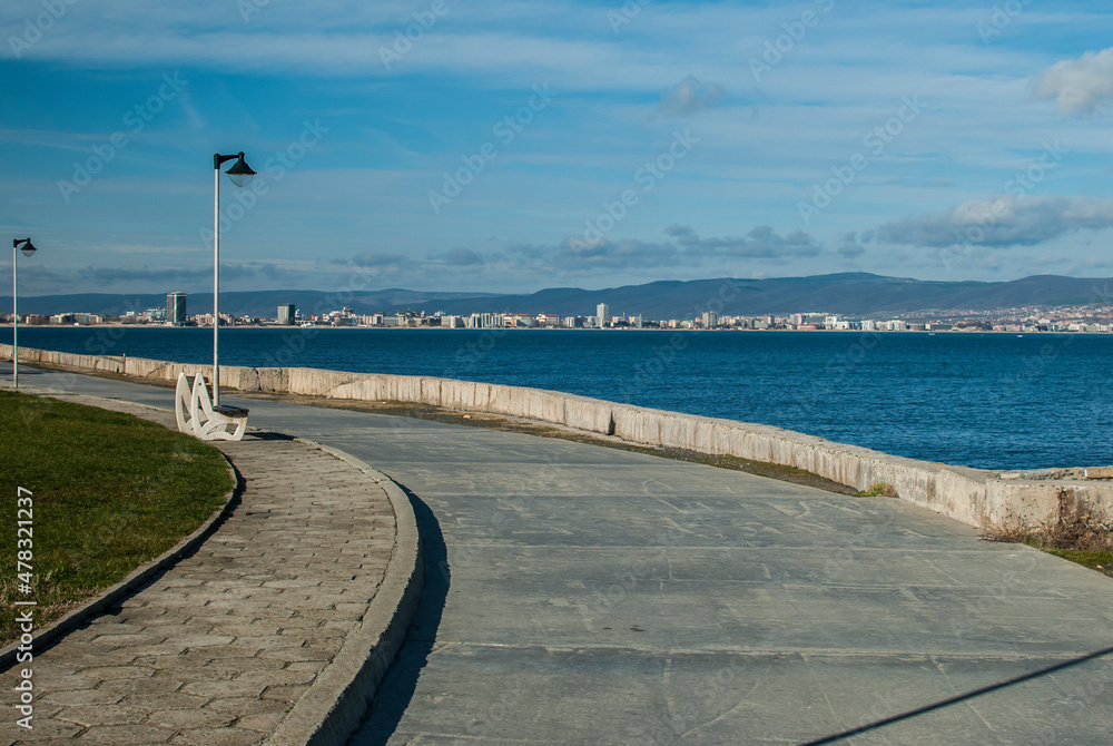 Panorama with deserted sea promenade alley in clear sunny day