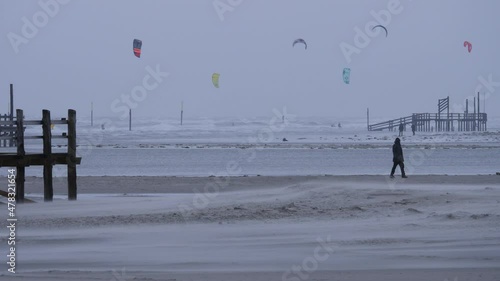 Kitesurfers on the beach in winter in St. Peter-Ording, Germany