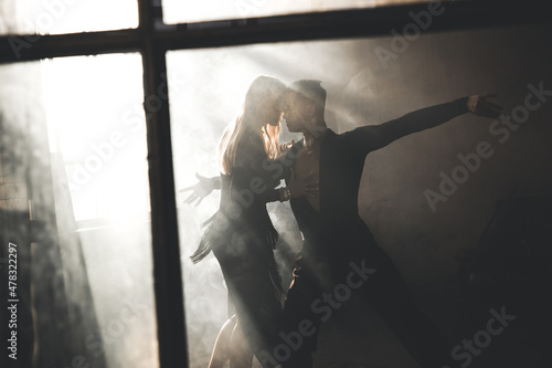 Canvas Couple of two professional ballroom dancers is dancing on loft studio