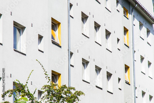Square windows in a grey plastered wall. Windows to the interior staircases have yellow niches.