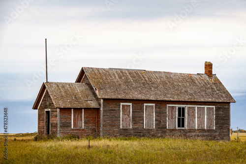 An old abandoned one room school house on the prairie of North Dakota in the evening.