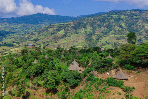 Panoramic View to the Tribal Wooden Dwellings among Green Grass and Trees in African Omo River Valley, Ethiopia photo