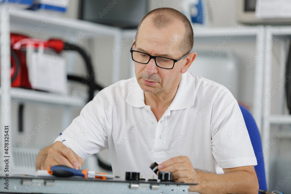 professional repairer working on device in his office