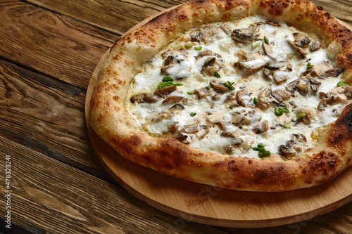 Appetizing pizza with mushrooms on a wooden tray