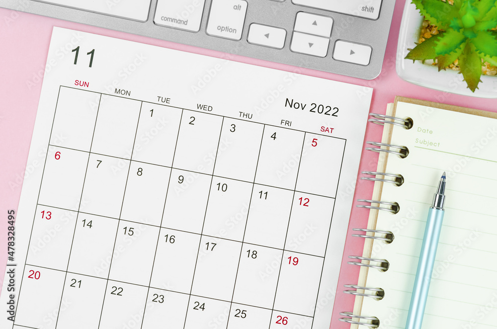 November 2022 calendar sheet with keyboard computer on pink background. November 2022 calendar sheet with keyboard computer on pink background.