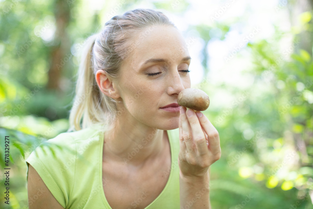 woman enjoying the smell of a freshly picked wild mushrooms woman enjoying the smell of a freshly picked wild mushrooms