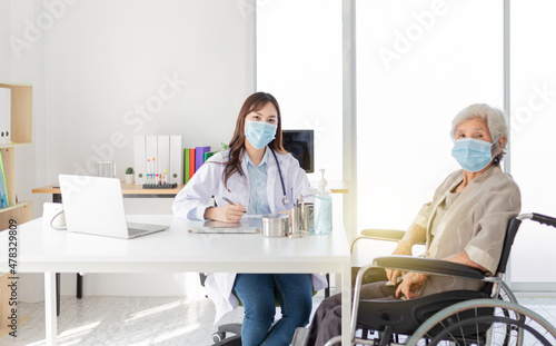 close up doctor  Asian doctor talk with old female patient about disease symptom  elderly health check up  they wear surgical mask in hospital
