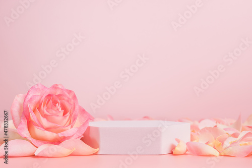 Fototapeta Naklejka Na Ścianę i Meble -  Empty podium with pink rose flowers on pink background to display products, gift or cosmetics. Podium with copy space for design or advertising