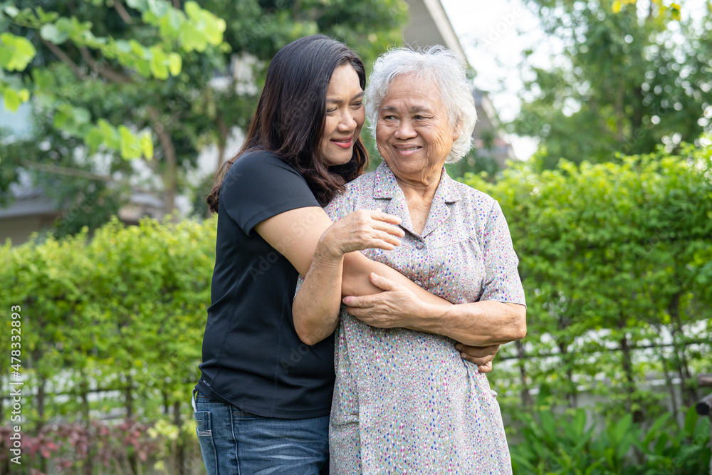 Asian elderly woman with caregiver daugther walking and hug with happy in nature park. Asian elderly woman with caregiver daugther walking and hug with happy in nature park.