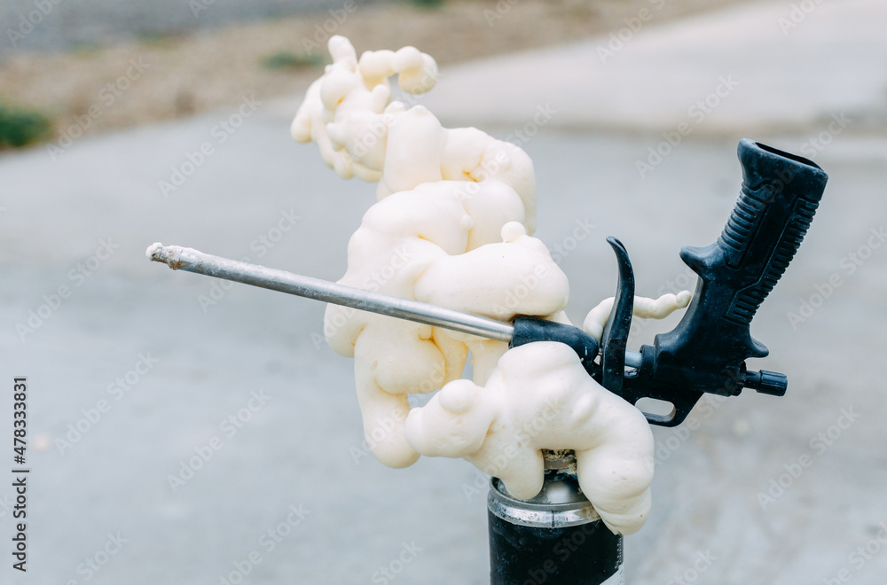 A gun for applying glue to foaming foam. Balloon foam. StockFoto Adobe Stock