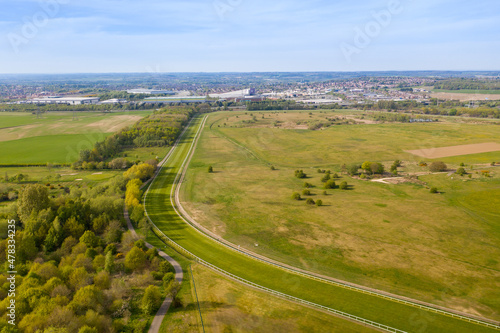 Aerial photo of the Pontefract race course located in the town of Pontefract in West Yorkshire in the UK, showing the main building and horse racing course, with the town of Castleford in the back