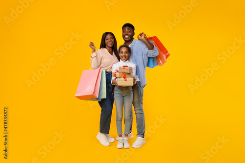 Happy black people holding shopping bags and gift boxes