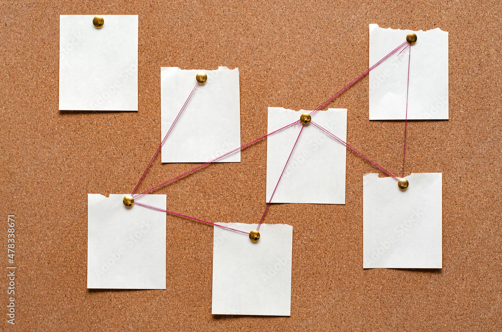 Blank paper notes are pinned to a cork board. The concept of detective investigation. Copy space. Blank paper notes are pinned to a cork board. The concept of detective investigation. Copy space.