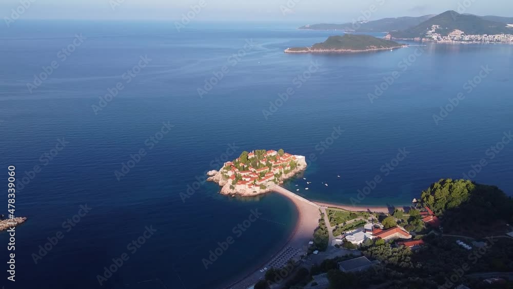 Bird's eye view of coastal zone with beautiful island and bridge. Main tourist location in the region. Drone shot of Sveti Stefan (Saint Stephen) island in Montenegro. Bird's eye view of coastal zone with beautiful island and bridge. Main tourist location in the region. Drone shot of Sveti Stefan (Saint Stephen) island in Montenegro.