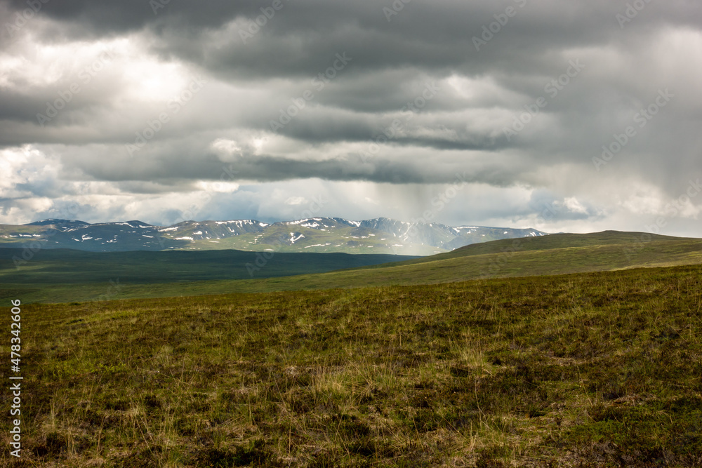 Rain falling  in the far distance seen from a campsite above the tree line Alaska's Northern Talkeetna Mountains. 