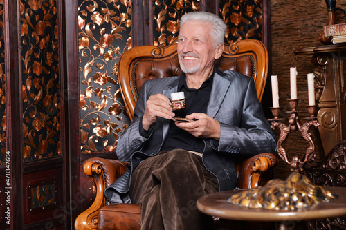 Portrait of smiling senior man drinking coffee at home