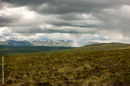 Rain falling in the far distance seen from a campsite above the tree line Alaska's Northern Talkeetna Mountains. 