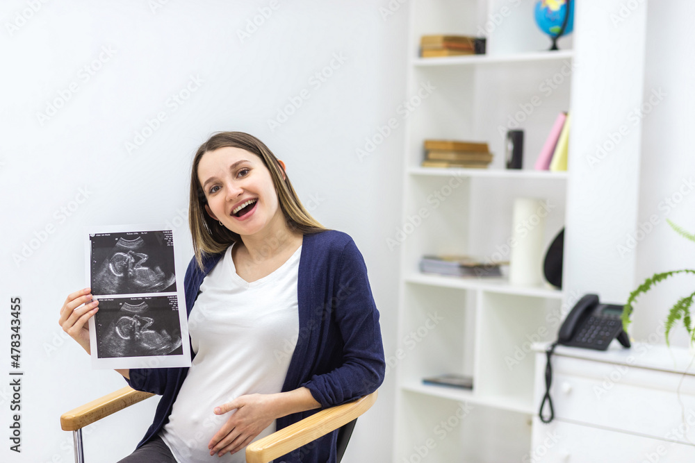 Photo of smiling pregnant woman with ultrasound result. Photo of smiling pregnant woman with ultrasound result.