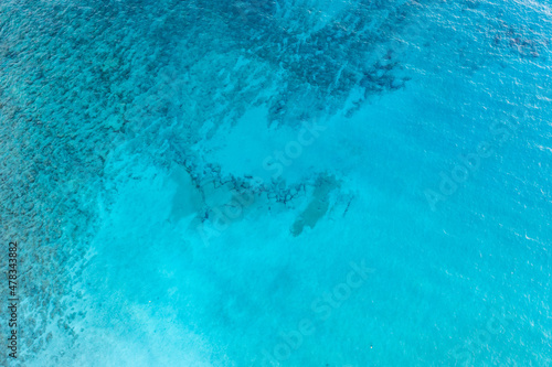 Sea surface turquoise blue color background, aerial drone view. Calm clear water with small ripples