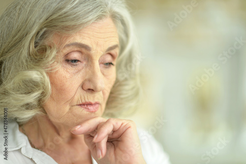 Portrait of beautiful sad senior woman posing at home