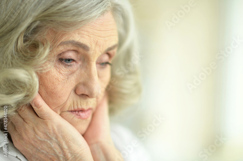 Portrait of beautiful sad senior woman posing at home