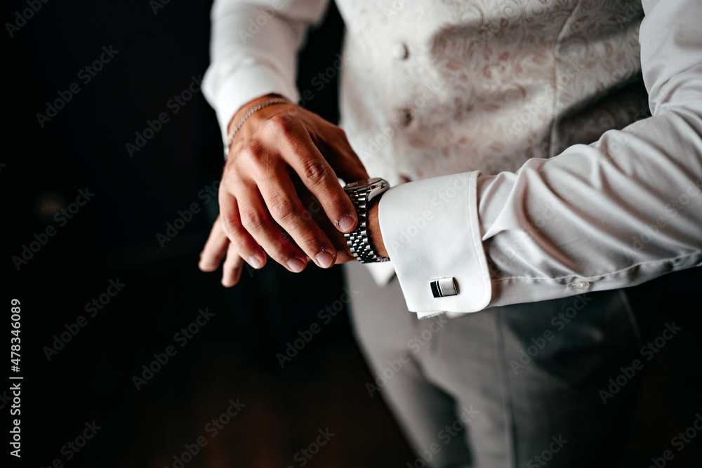 Ein festlich gekleideter Mann schaut auf seine Uhr