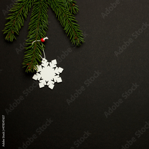 Christmas tree with a snowflake toy on a black background. Christmas concept.
