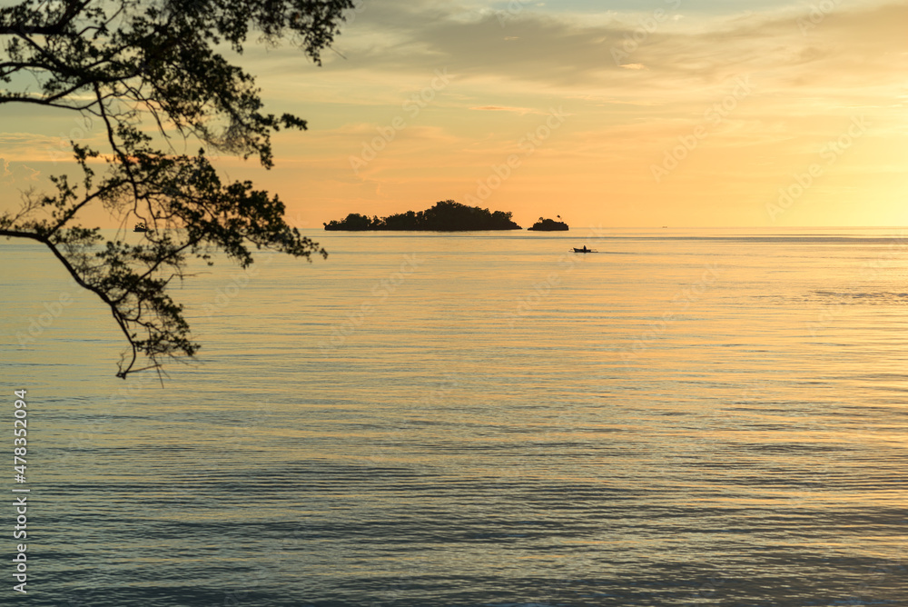 Φωτογραφία Outrigger canoe at sunset in the Gulf of Tomini, seen from the Togian Island Batudaka in the north of Sulawesi in Indonesia