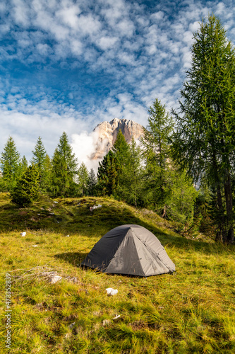 Sunrise morning view of green tent and Tofane mountains Tofana di Rozes in background. Autumn camping in Dolomites, Trentino Alto Adige region, South Tyrol, Italy, Europe.