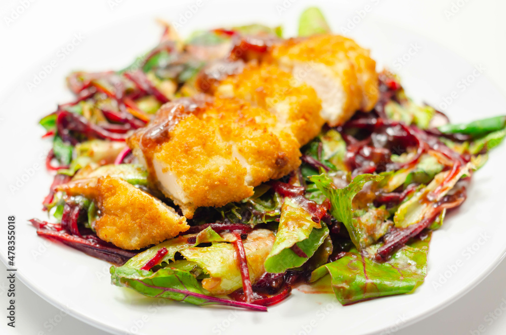 Breaded crispy chicken breast fillet with mixed salad and grated beetroot Breaded crispy chicken breast fillet with mixed salad and grated beetroot