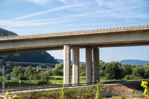 Large modern concrete bridge on four posts in the landscape with blue sky in the background © Mentor