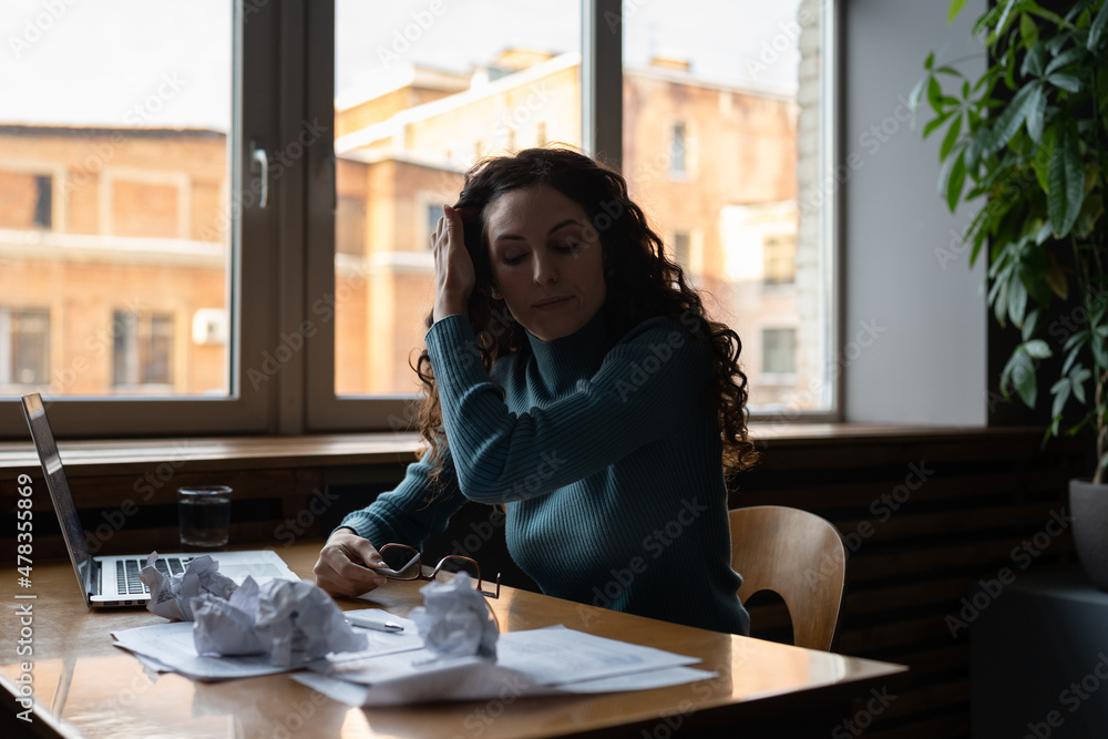 Tired overworked woman at workplace, sitting in front of laptop at messy office table, depressed female writer cant generate ideas or having lack inspiration. Office worker suffering from job burnout Tired overworked woman at workplace, sitting in front of laptop at messy office table, depressed female writer cant generate ideas or having lack inspiration. Office worker suffering from job burnout
