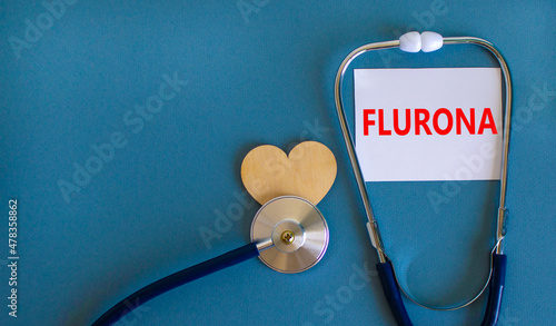Covid-19 corona and flu flurona symbol. The concept word flurona on wooden block and stethoscope. Wooden heart. Beautiful blue background. Medical, covid-19 corona and flu flurona concept. Copy space.