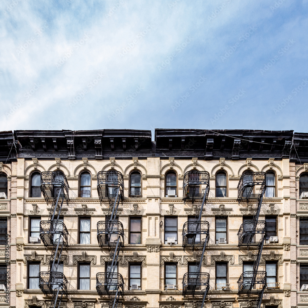 Old apartment buildings in the Lower East Side neighborhood of New York City with empty blue sky background above