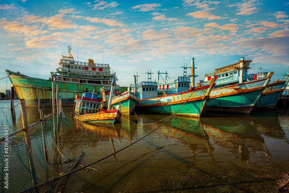 Fishing port and beautiful sky in Asia,Many boats moored in sunrise morning time at Chalong port, Main port for travel ship to krabi and phi phi island, Phuket, Thailand