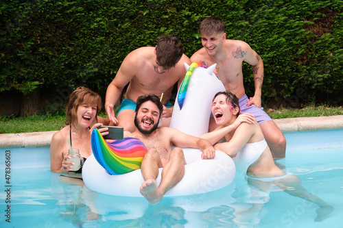 Group of people drinking lemonade and taking a selfie in a swimming pool.