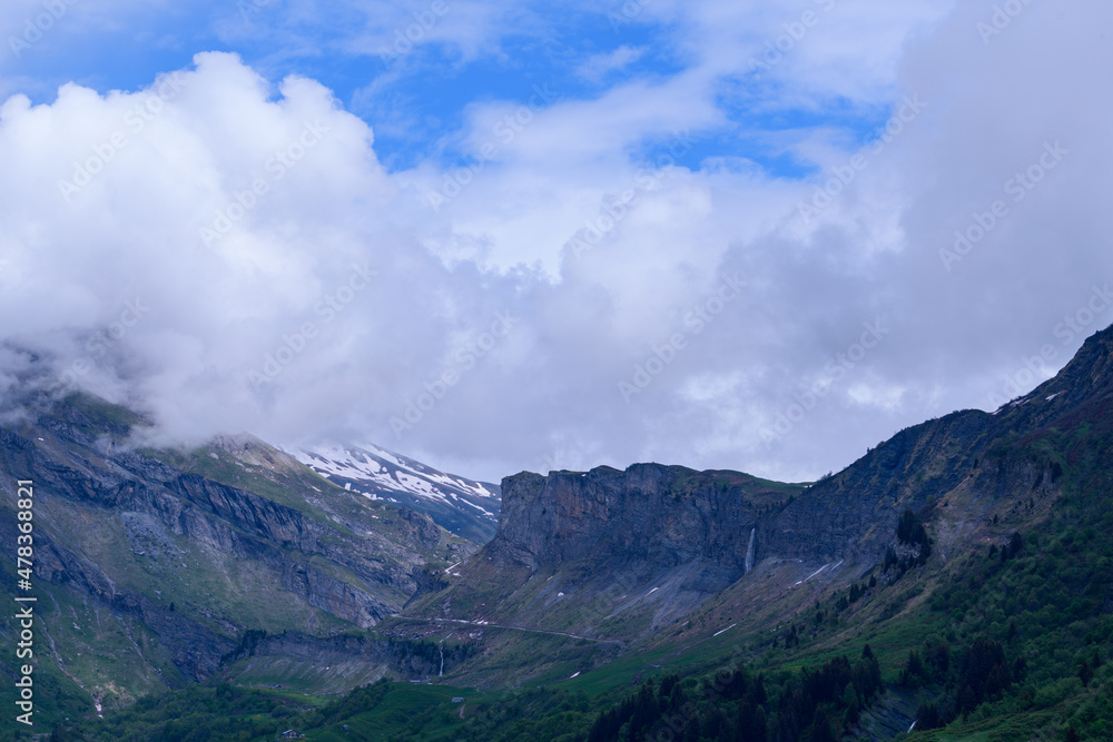 The mountains of the countryside around the Roselend dam in Europe, France, the Alps, towards Beaufort, the Alps, in the summer on a cloudy day. The mountains of the countryside around the Roselend dam in Europe, France, the Alps, towards Beaufort, the Alps, in the summer on a cloudy day.