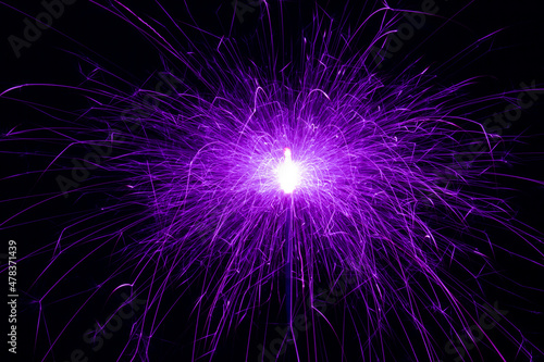 Sparkler  purple sparks on a black background. Abstract photo of sparks  holiday lights