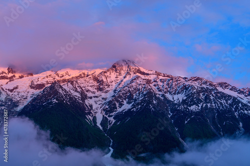 The Mont Blanc Massif in pink clouds in Europe, France, the Alps, towards Chamonix, in summer.