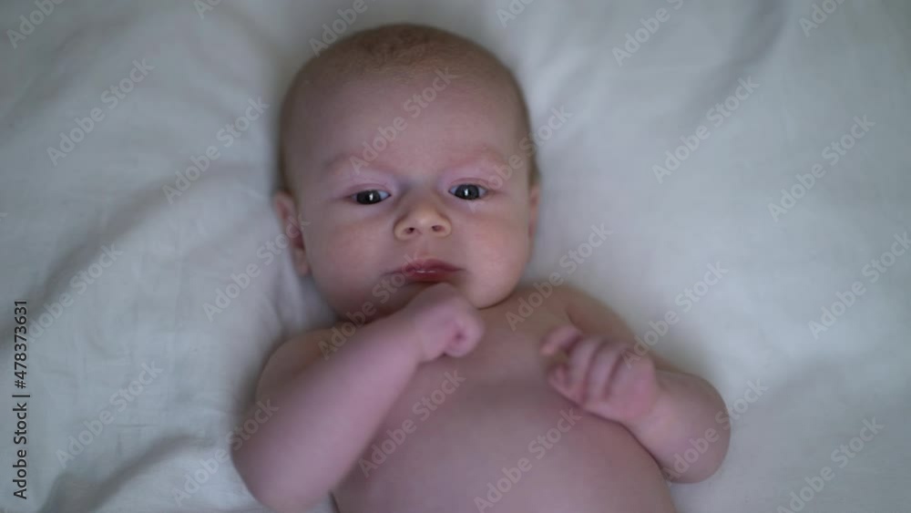 Little caucasian newborn baby lying at the back in the child crib. Little caucasian newborn baby lying at the back in the child crib.