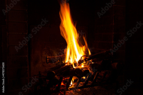 bright flame of fire burns in a fireplace in the old house in winter evening