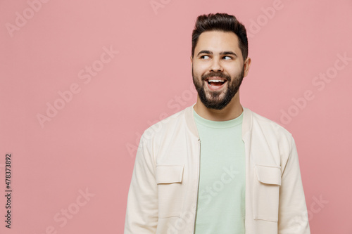 Young smiling cheerful happy caucasian man 20s wearing trendy jacket shirt look aside on workspace area mock up isolated on plain pastel light pink background studio portrait People lifestyle concept © ViDi Studio