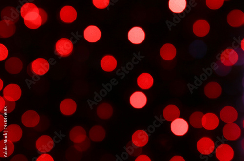 Beautiful night bokeh from red garlands on a black background.