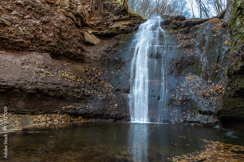 Tranquil waterfall scenery in the middle of autumn forest