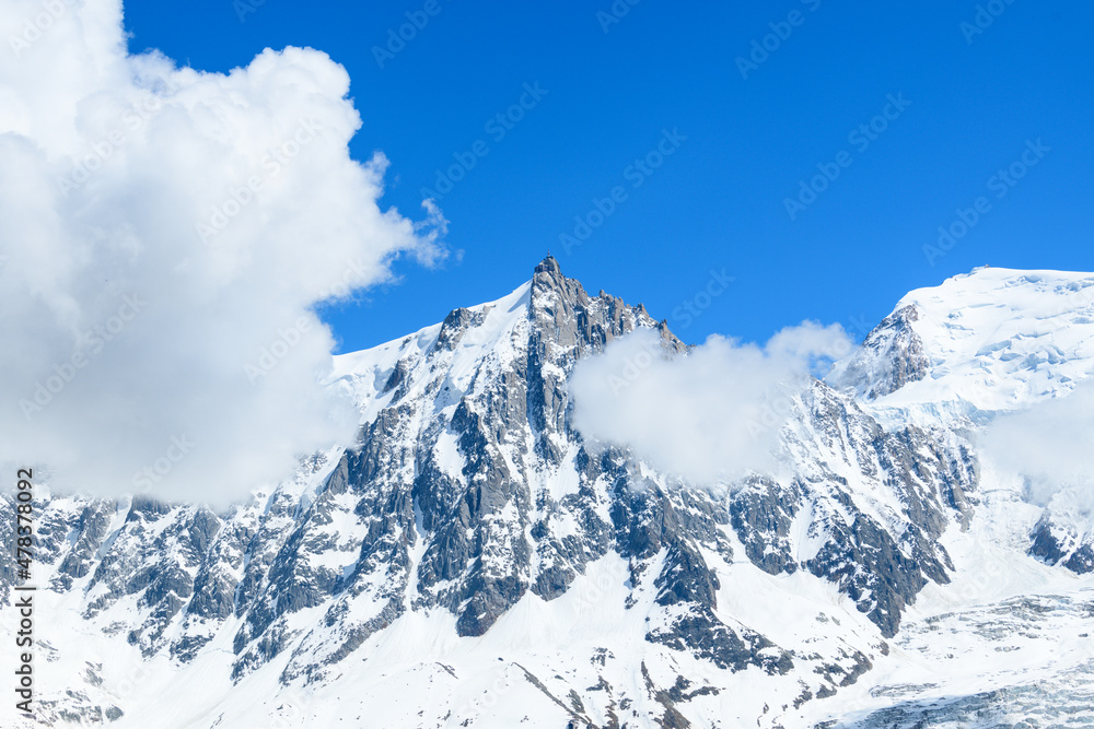 Obraz premium Clouds frame the Aiguille du Midi in the Mont Blanc massif in Europe, France, the Alps, towards Chamonix, in summer, on a sunny day.