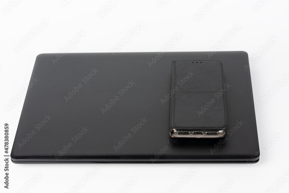 Modern, new office black laptop and touchscreen smarthphone in leather case on white background Modern, new office black laptop and touchscreen smarthphone in leather case on white background