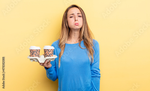 pretty woman feeling sad and whiney with an unhappy look and crying. take away coffee concept photo